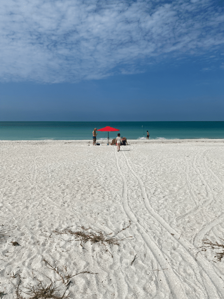 Anna Maria Island beach with young girl and chairs with umbrellas