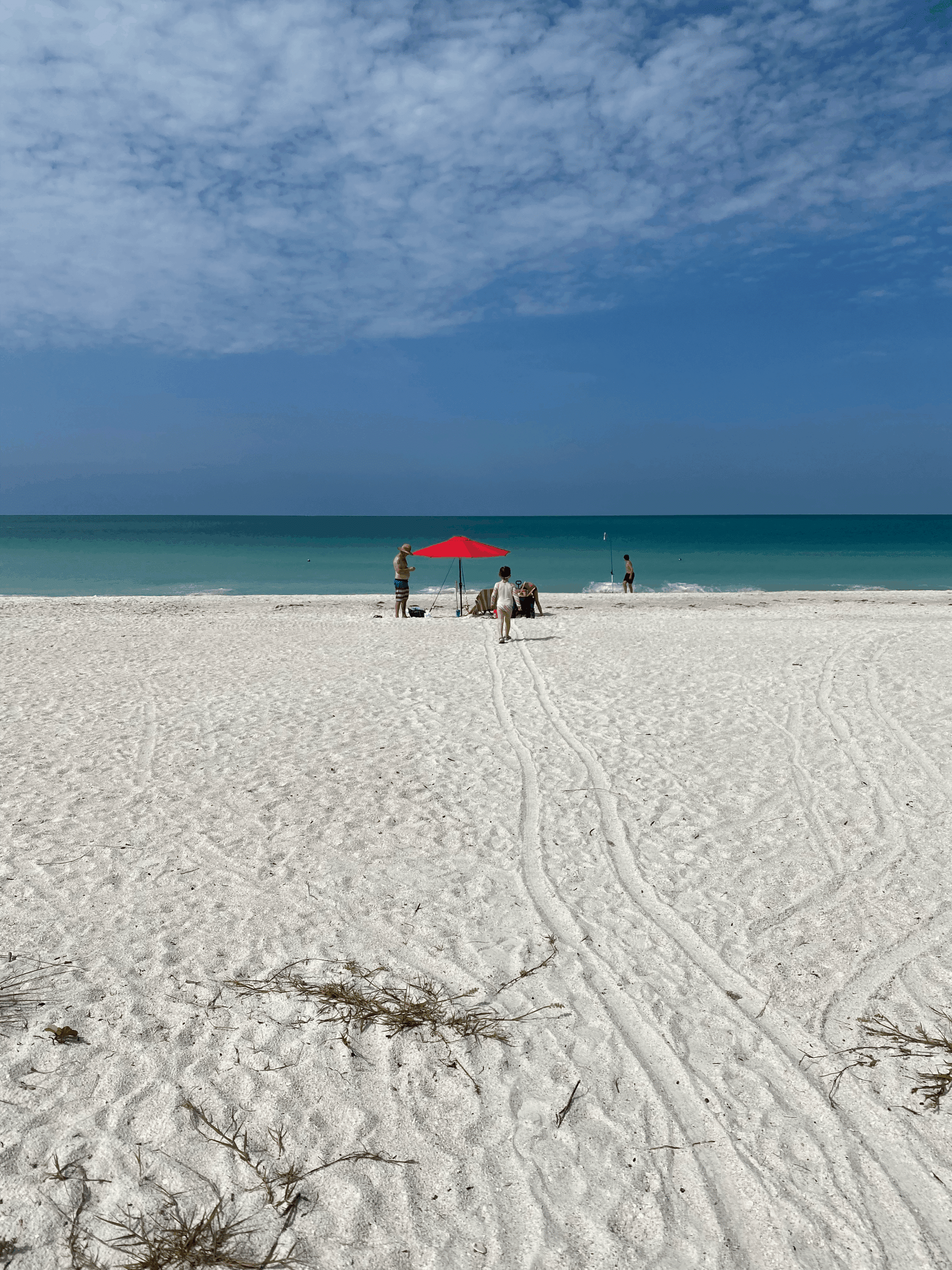 Anna Maria Island beach with young girl and chairs with umbrellas
